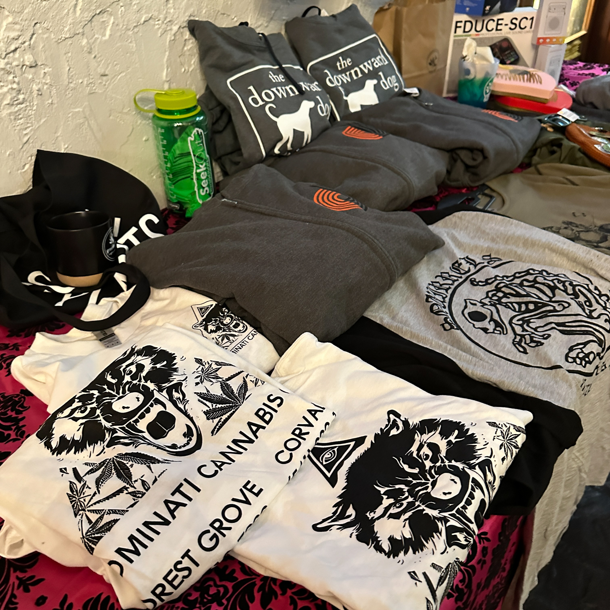 Table with t-shirts on display from local businesses.